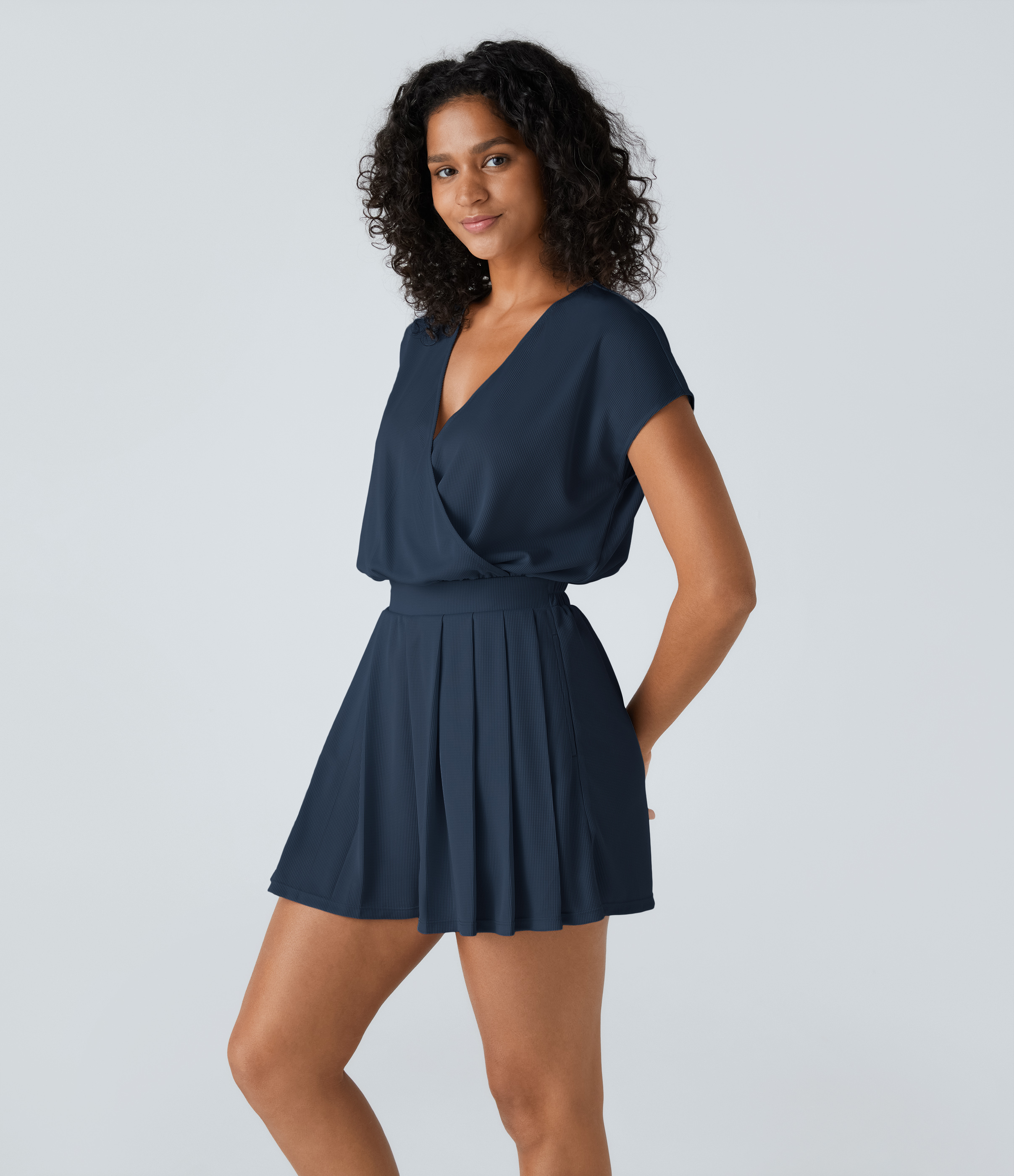 Flowy V-neck playsuit with pleats, short sleeves, and waffle-patterned side pocket