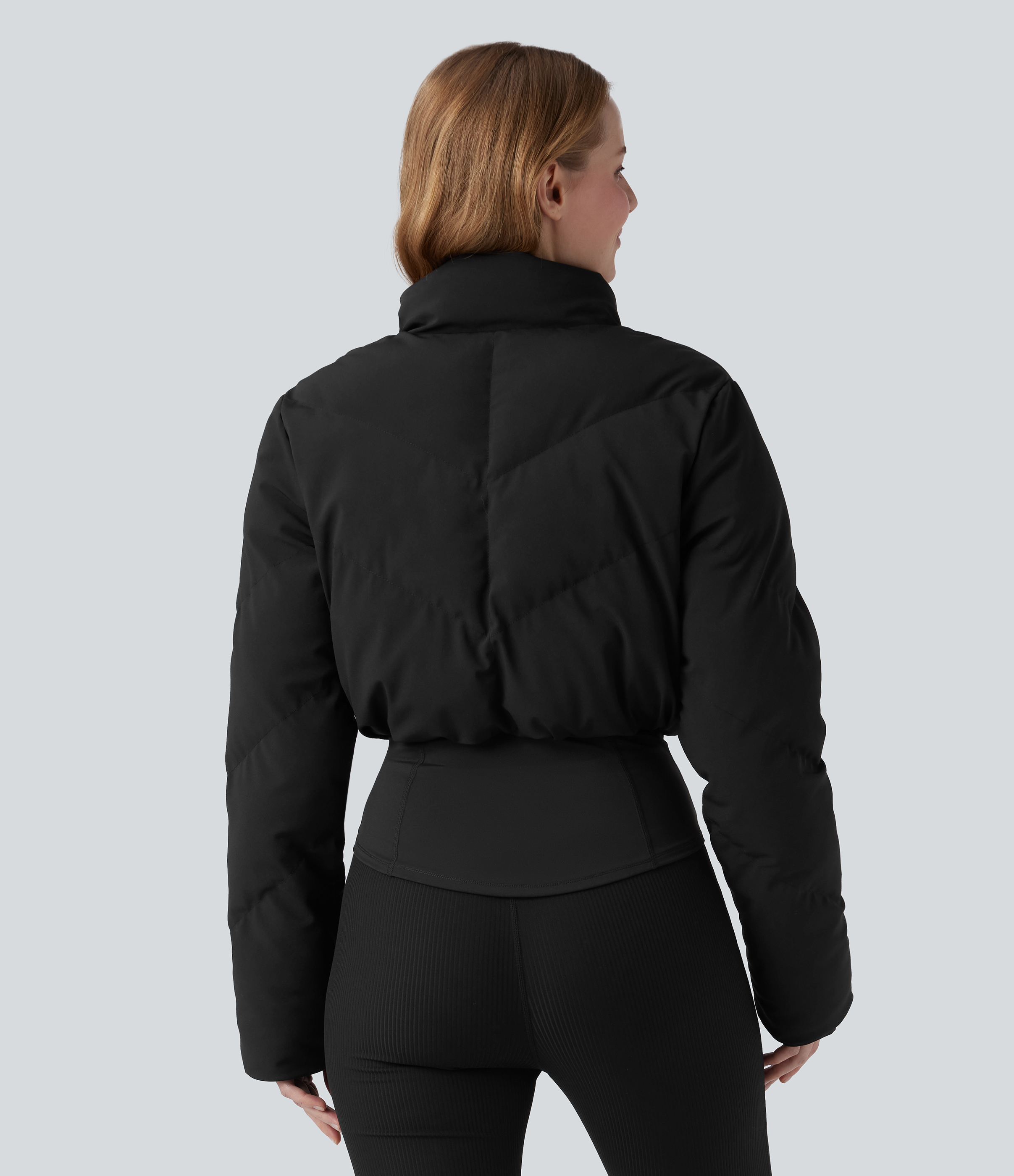 Schwarz Legere, kurz geschnittene Steppjacke mit Stehkragen & Jacke mit Daumenlöchern, abgerundetem Saum und Tasche / 2