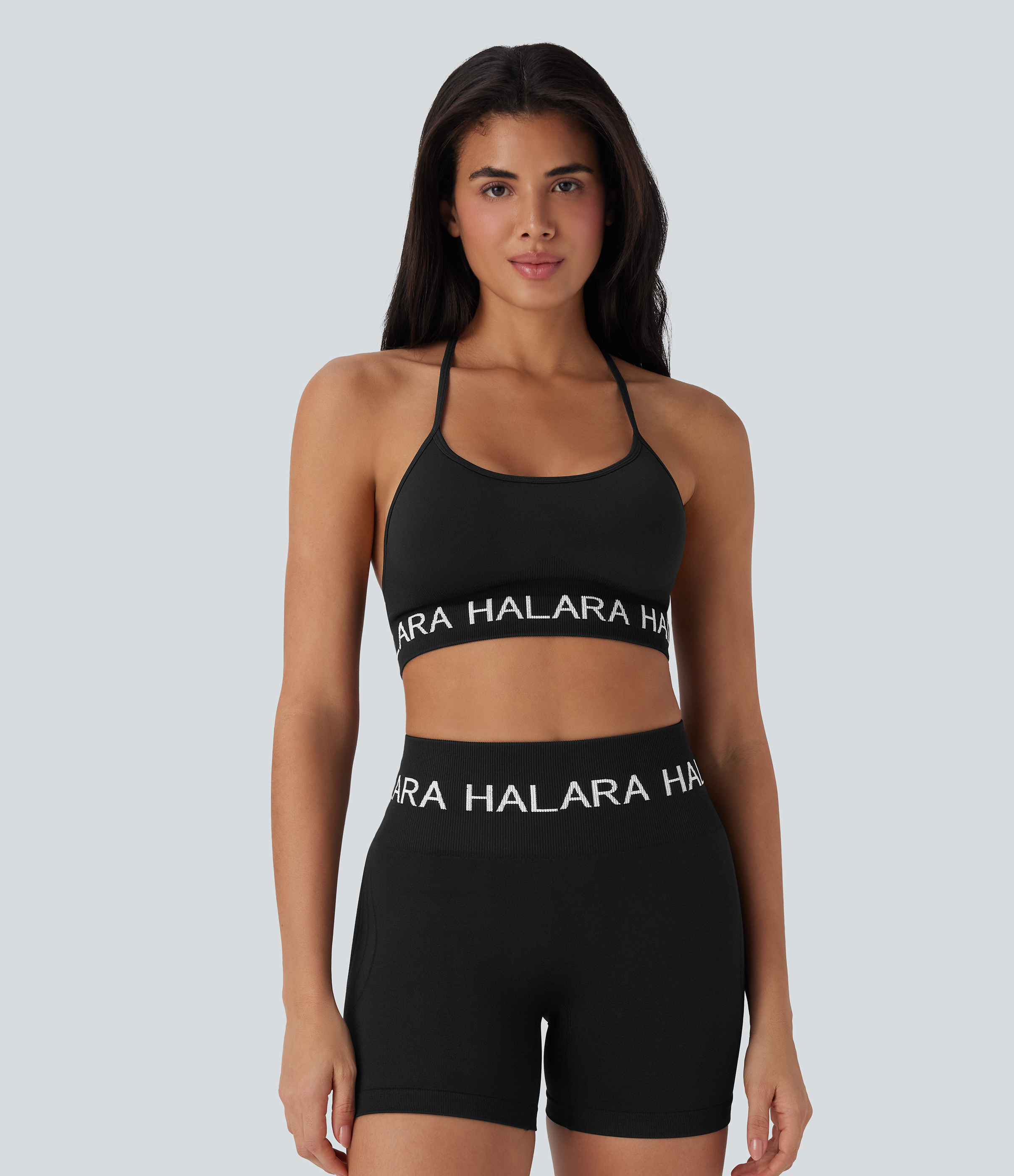 Black Sujetador deportivo de yoga sin costuras de sujeción baja con espalda abierta, cuello halter, tirantes ajustables y con el logo Halara / 1