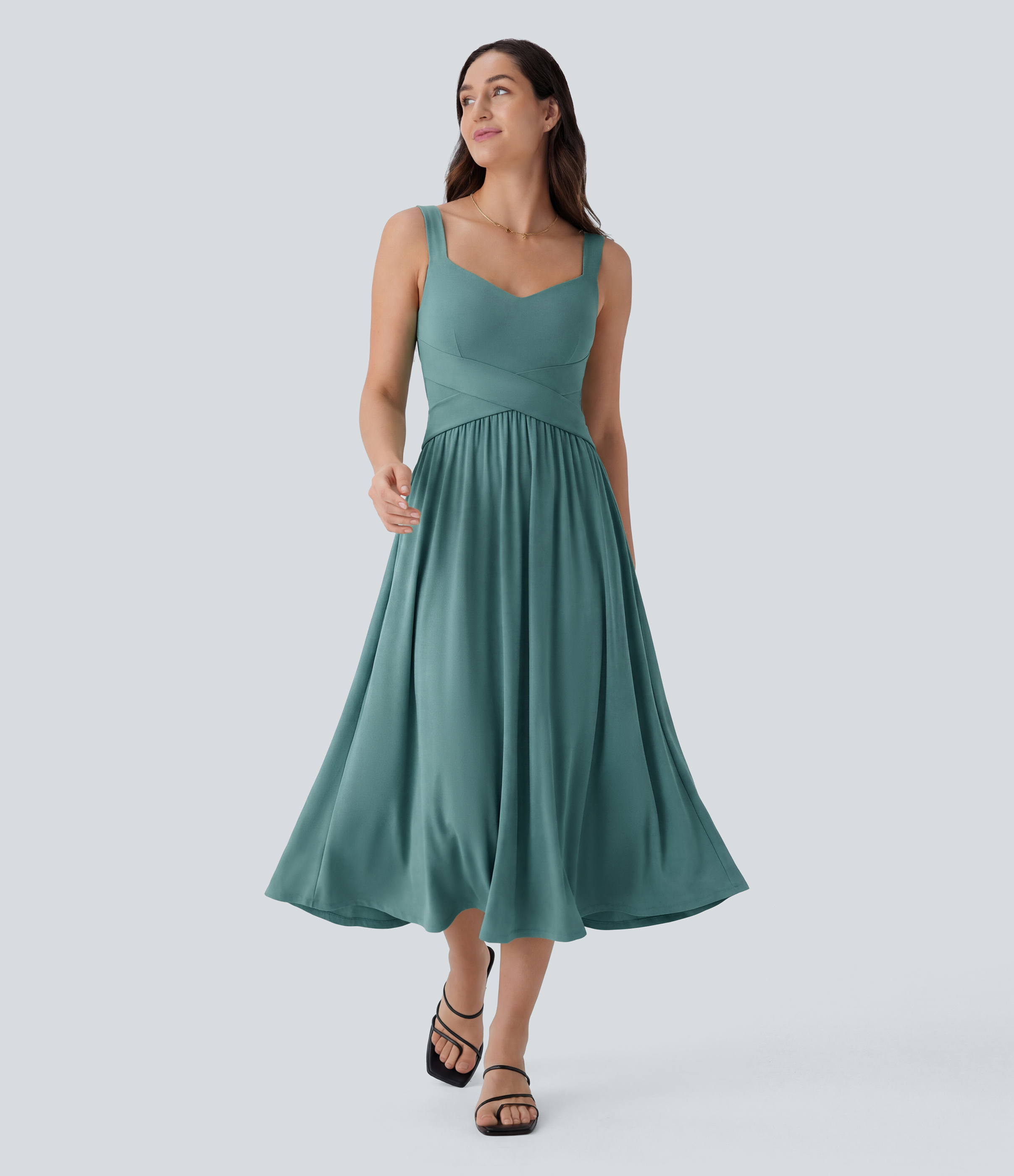 Vestido midi fluido, sin espalda, sin mangas, con bolsillos laterales y diseño entrecruzado.