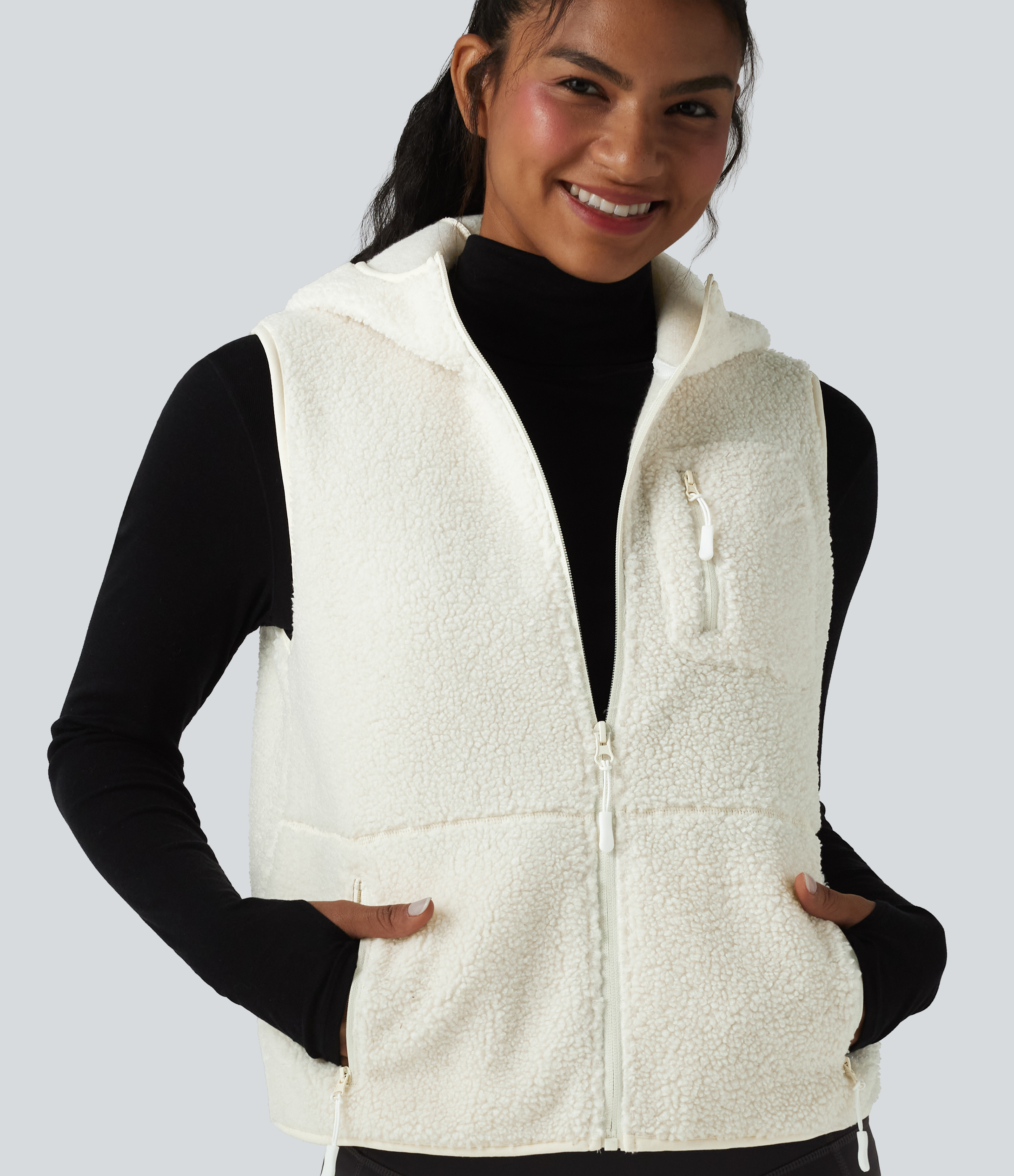 Sports vest made of sherpa fleece with hood and several pockets